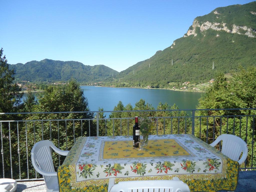 einen Tisch mit einer Flasche Wein auf einem Balkon mit einem See in der Unterkunft Villa Carlotta in Crone