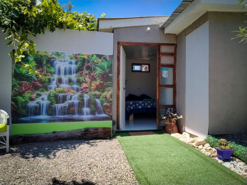 a house with a waterfall mural on the wall at Casa Jupiter in Villa Alemana