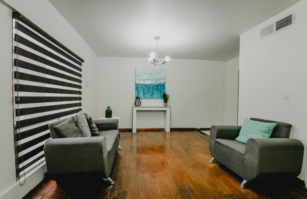 a living room with two chairs and a table at Casa Prisma amplitud y privacidad in Chihuahua