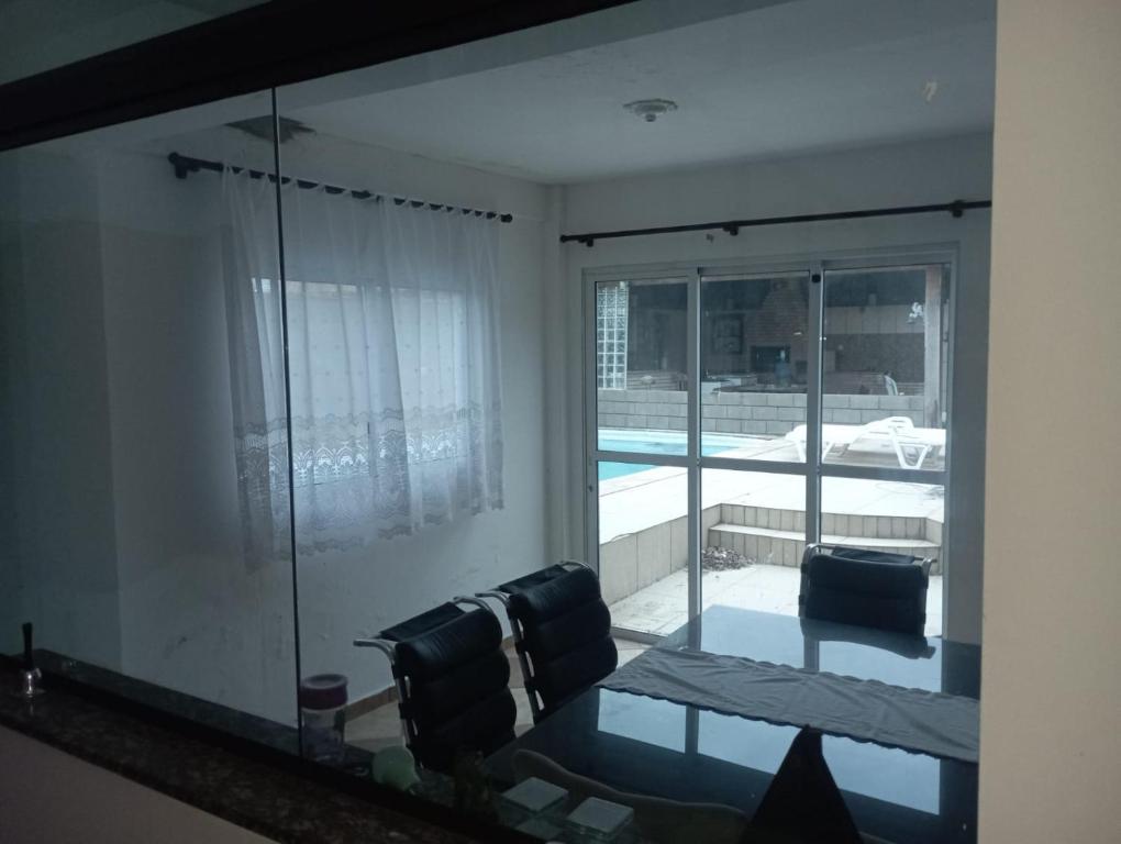 a mirror in a living room with a view of a pool at Hostel da Duda II in Itanhaém