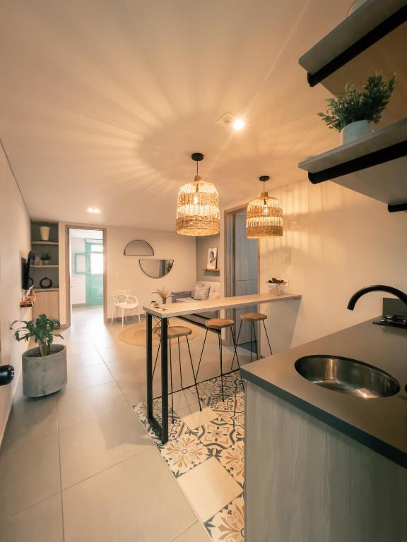 a kitchen with two chandeliers and a sink in a room at Parallelo Loft Salento P1 in Salento