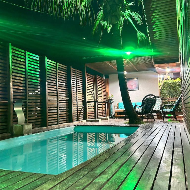 a swimming pool next to a house with a palm tree at Chalé com PISCINA Privativa, com 2 QUARTOS, ESTACIONAMENTO em Condomínio com PORTARIA 24h, Sauna, Quadras, 3 PISCINAS no condomínio, Pesca e Parquinho Infantil - SmarTV na sala de estar, TV na área CHURRASQUEIRA, Wi-Fi e Cozinha Completa in Atibaia
