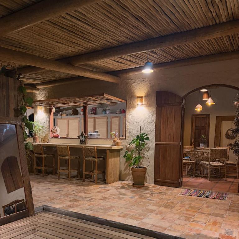 a large kitchen with a wooden ceiling and a table at Casa Kaûma in Corumbau