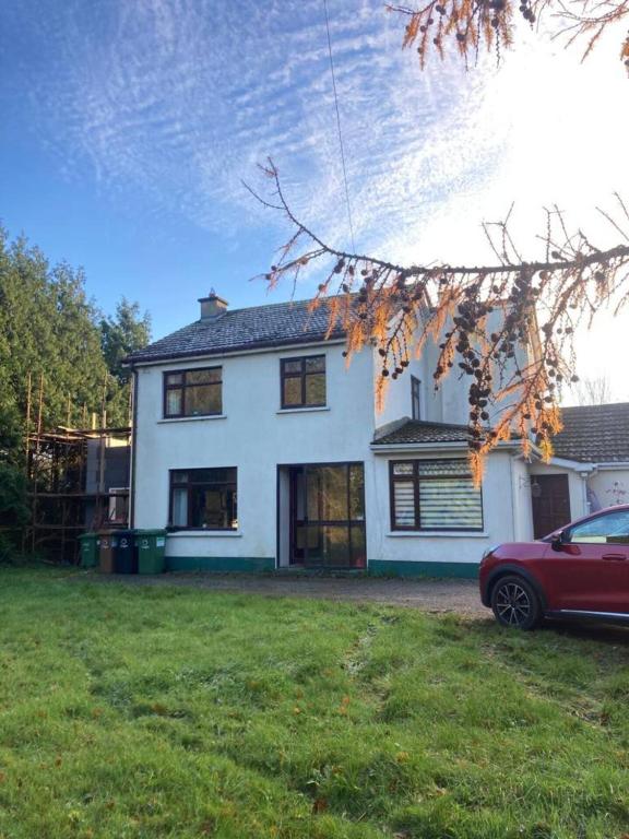 a white house with a red car parked in the yard at Leixlip 4-Bed Home Sleeps 6 Ideal for Groups in Kildare