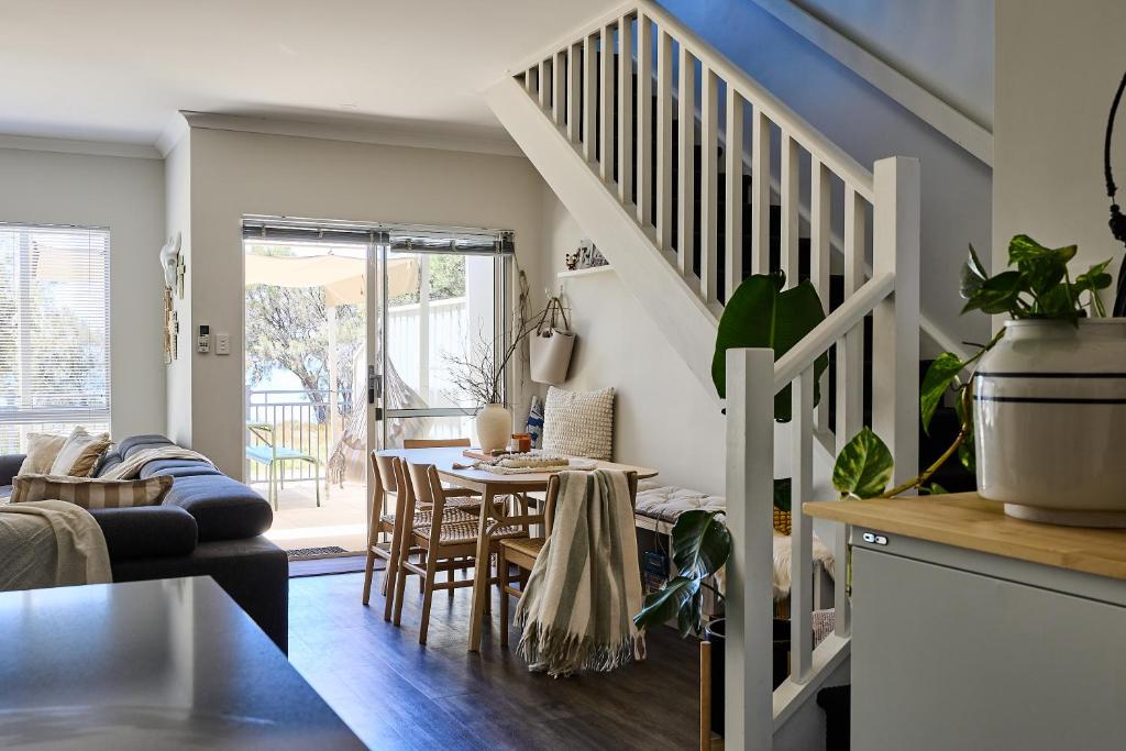 a living room with a dining room table and stairs at Water's Edge 4x4 Townhouse in Falcon