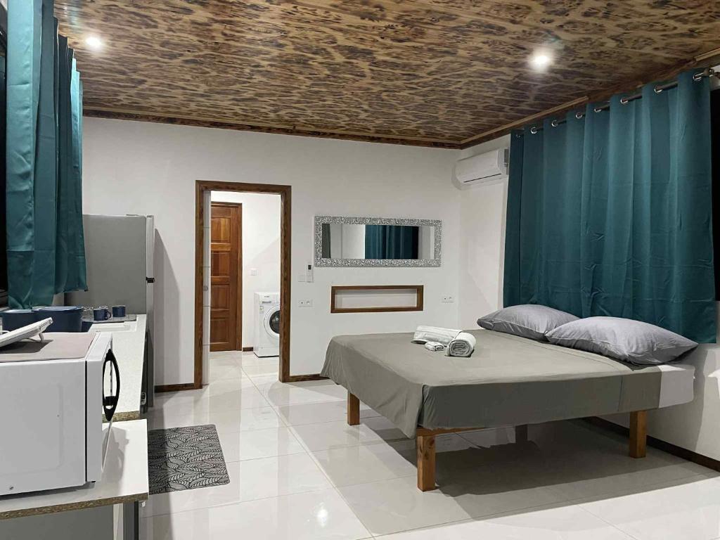 a bedroom with a bed and a bathroom with a sink at Havaii Spot Huahine in HUH