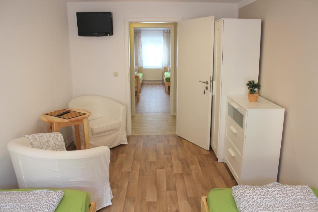 a room with a living room with a table and chairs at Doppelzimmer - Monteurswohnung - Arbeiterwohnung 4-8 Personen in Plaue