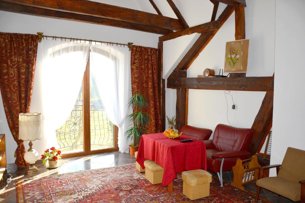 a living room with a red table and a chair at Agrotur-Maya in Gorzyca