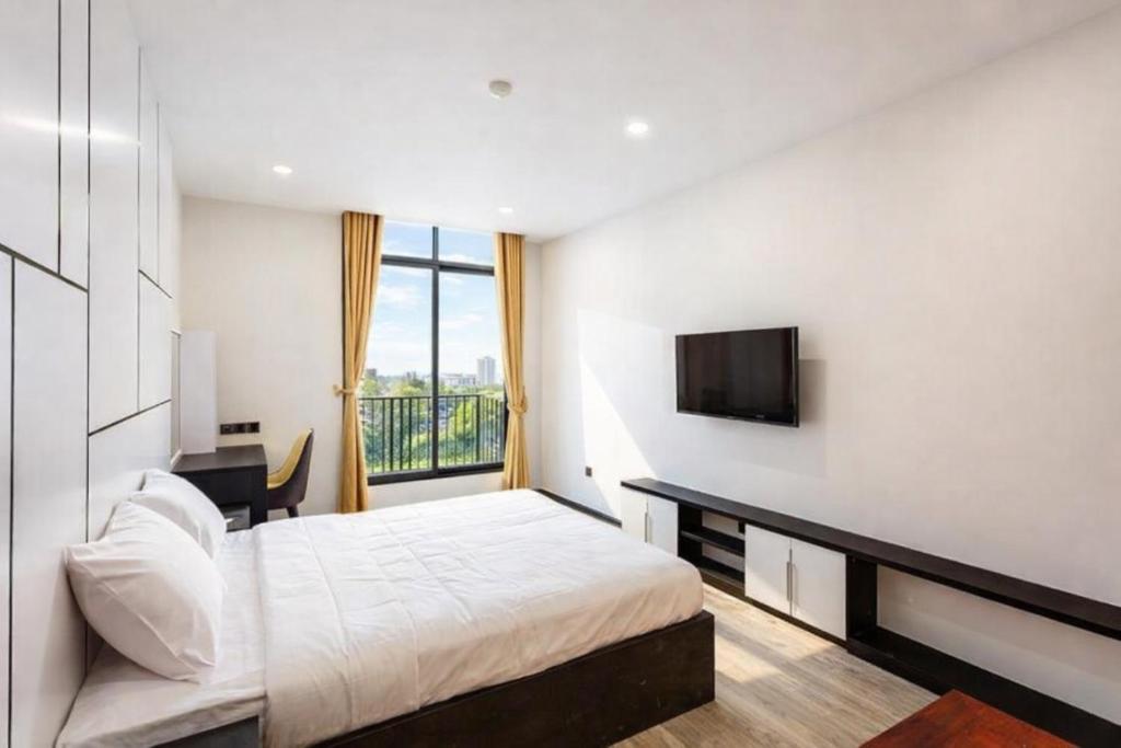 a hotel room with a bed and a television at Thúy Apartment Hải Phòng in Hai Phong