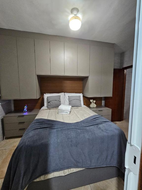 a bedroom with a large bed with a blue blanket at Brisa Do Mar in Saquarema