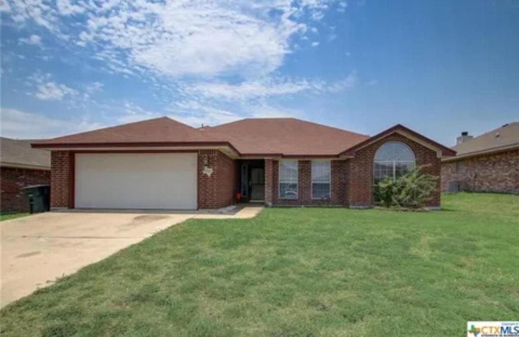 a brick house with a white garage at Kindness Dwells in Killeen