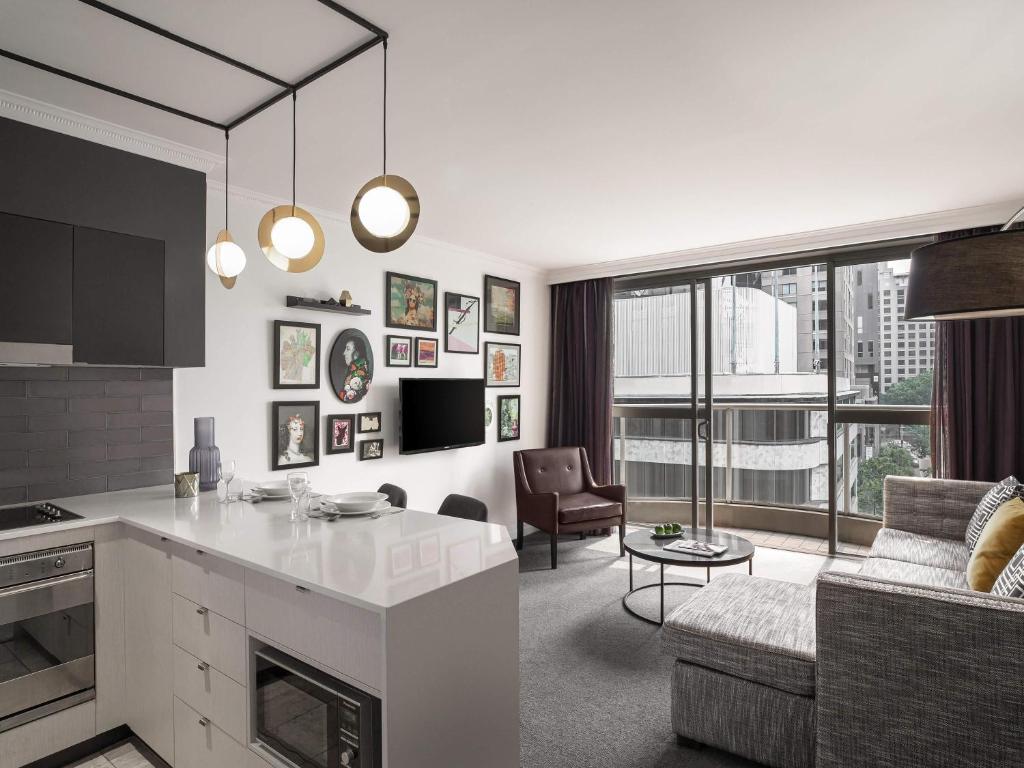 a kitchen and living room with a couch and a table at Mantra 2 Bond Street in Sydney