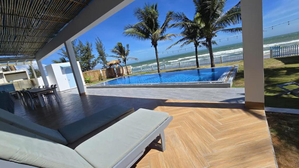 a living room with a couch and a swimming pool at Beach Villas Phan Thiêt in Bình Sum