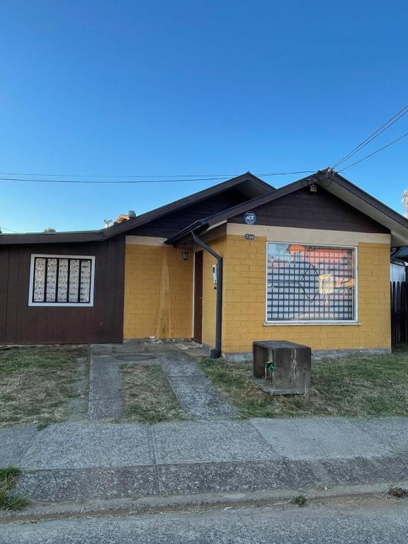 a yellow house with a sign on the side of it at Casa Barrio Santa Elena in Valdivia