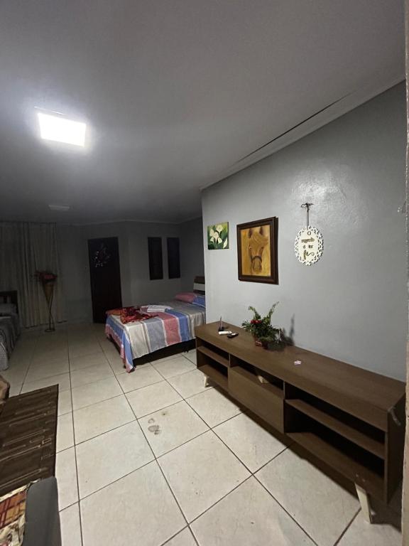 a bedroom with a bed and a table in it at Drica Pousada in São Gabriel