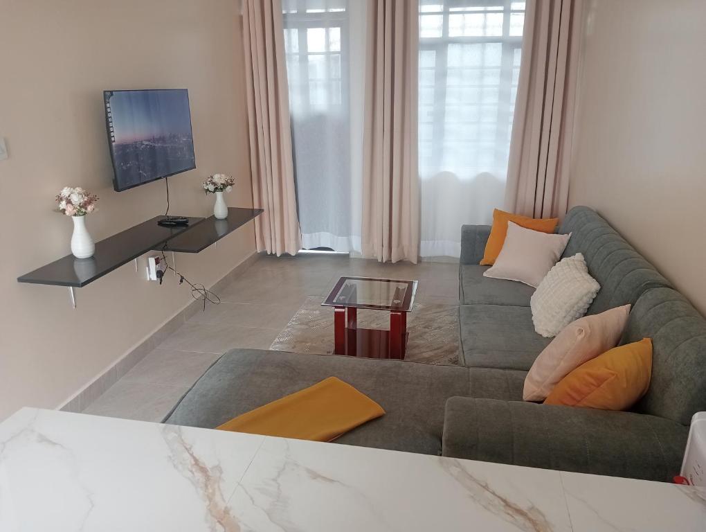 a living room with a couch and a tv at Shanvinhomes -1 bedroom Apartment in Skuta-Nyeri Town in Nyeri