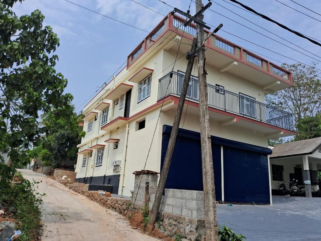 a white and blue building with a balcony at AP'S Homestay Nilambur in Nilambūr