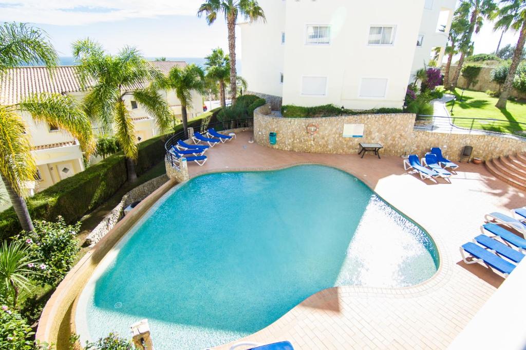 an overhead view of a swimming pool with blue lounge chairs at Akisol Lagos Relax III in Lagos