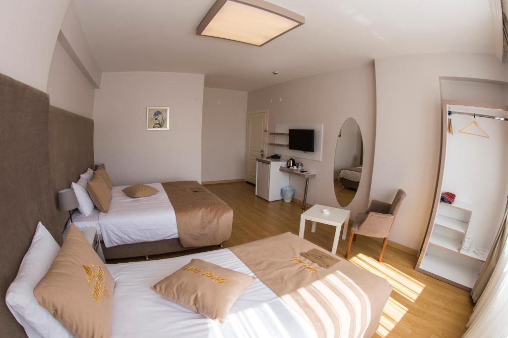 CorumにあるBilge Suite Hotelのベッド2台とバスルームが備わるホテルルームです。
