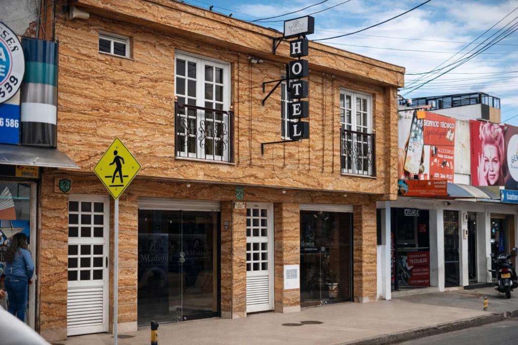 a brick building with a sign on a street at Hotel Restaurante El Madroño Chia in Chía