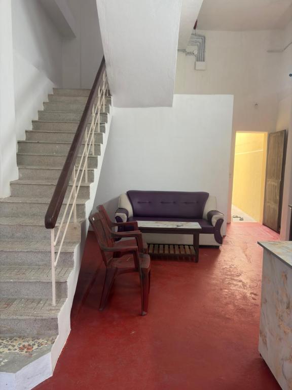 a living room with a couch and a staircase at Eiffel Pondy in Pondicherry