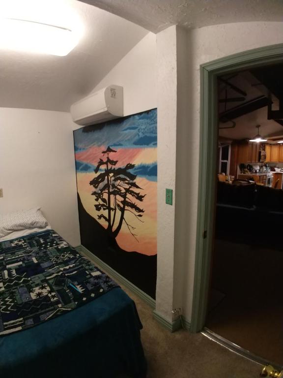 a bedroom with a painting of a tree on the wall at Gerardín in Flagstaff