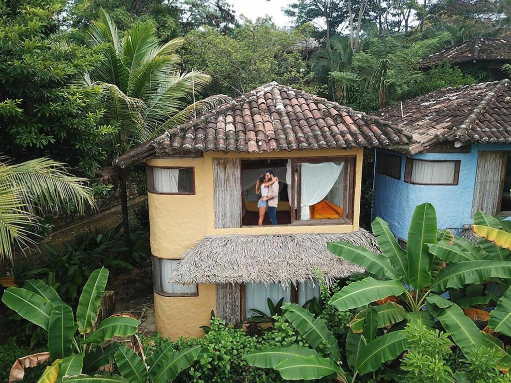 a person standing in a window of a house at Ecolodge Rancho del Lago in Santomé