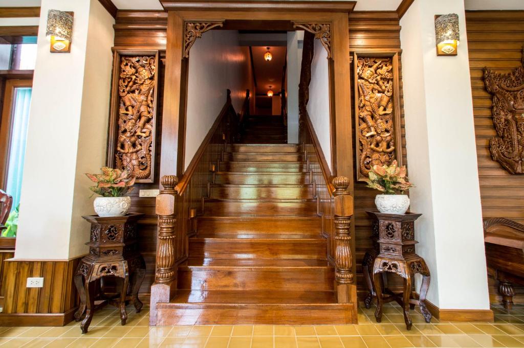 a staircase in a home with wood paneling and floors at Villa Sirilanna Hotel in Chiang Mai