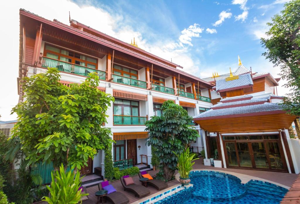 a hotel with a swimming pool in front of it at Villa Sirilanna Hotel in Chiang Mai