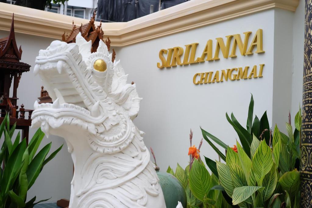 a white statue in front of a santamaria chinese sign at Villa Sirilanna Hotel in Chiang Mai