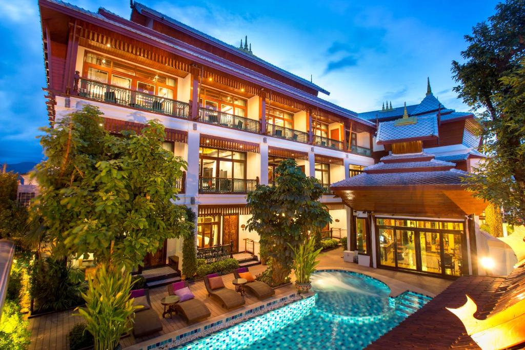 an exterior view of a hotel with a swimming pool at Villa Sirilanna Hotel in Chiang Mai