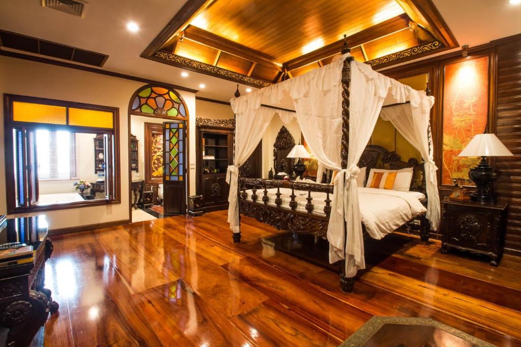a bedroom with a canopy bed in a room at Villa Sirilanna Hotel in Chiang Mai