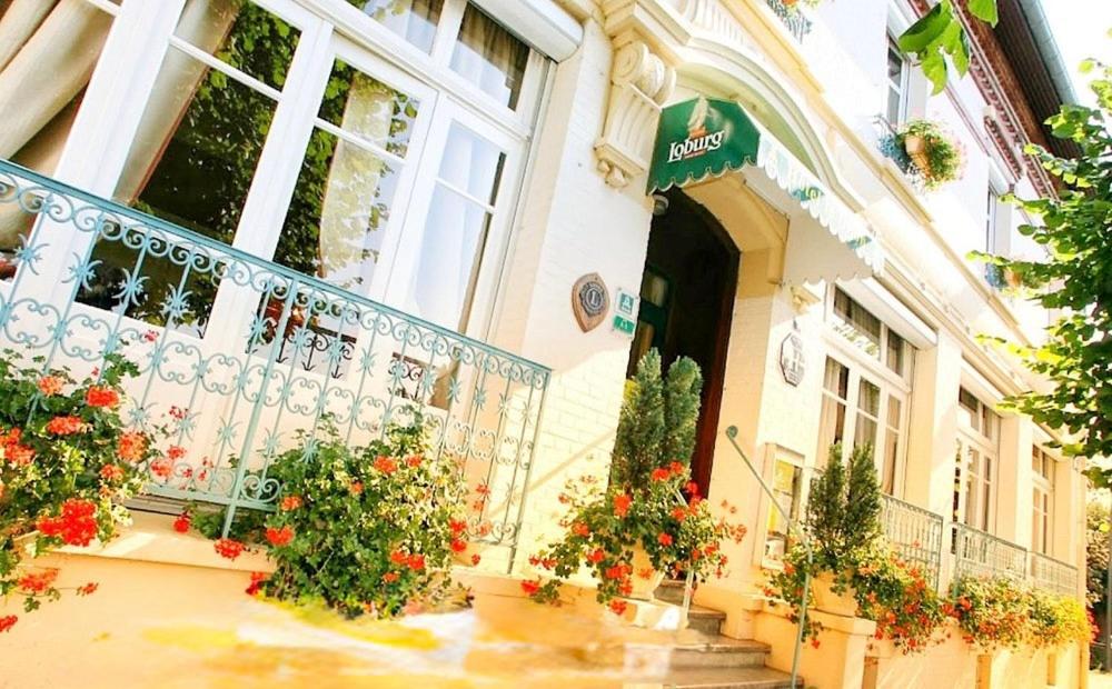 a building with a balcony with flowers on it at Le Renaissance in Montdidier