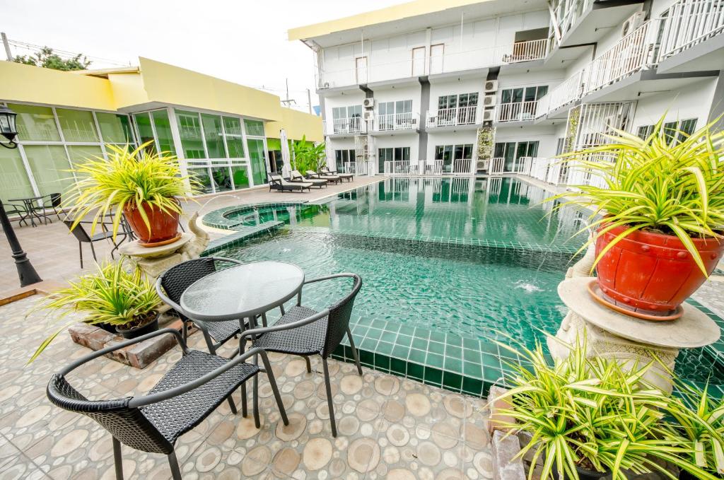 a swimming pool in a building with chairs and a table at Anantra Pattaya Resort in Pattaya