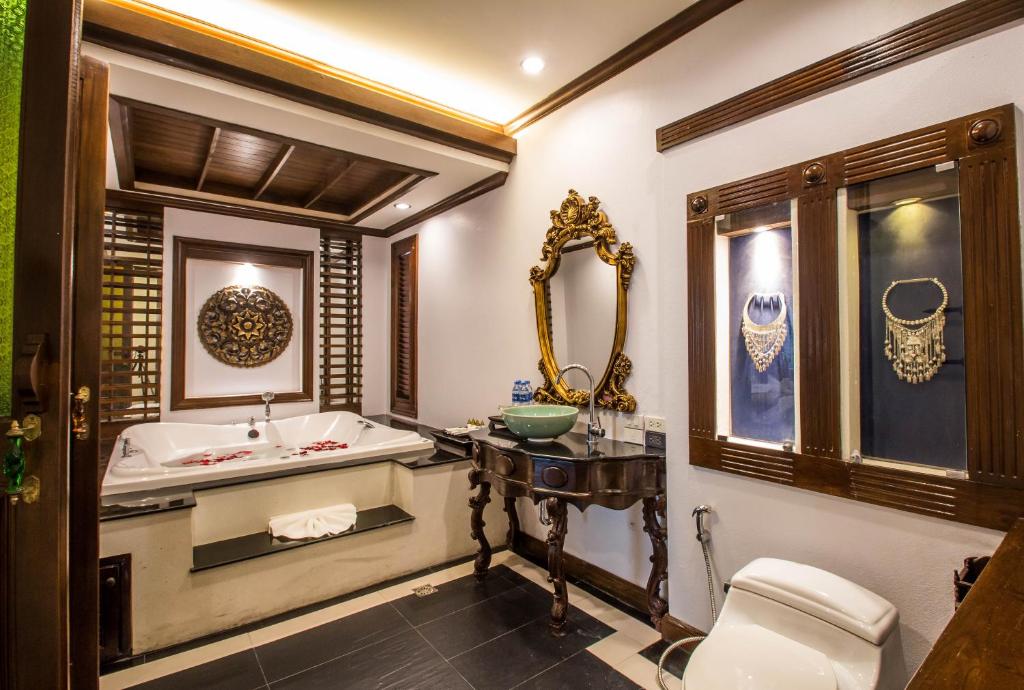 a bathroom with a tub and a sink and a toilet at Villa Sirilanna Hotel in Chiang Mai
