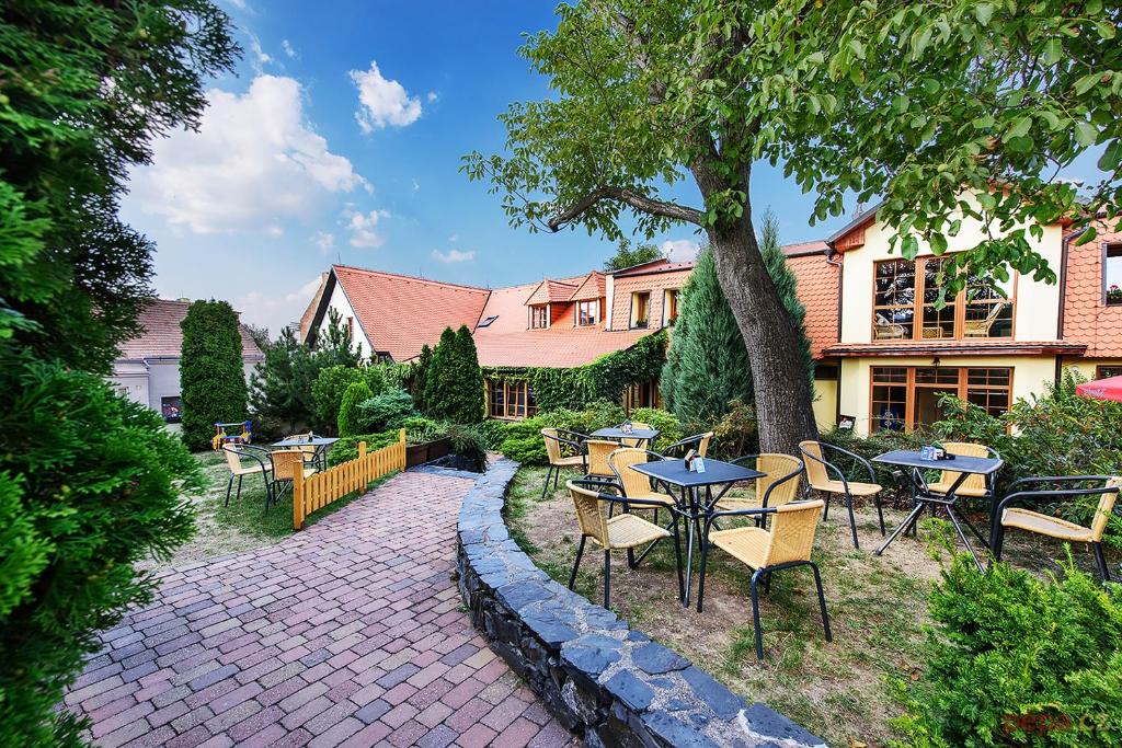 un patio con mesas y sillas frente a una casa en Restaurace a Penzion U Palečků, en Skuteč