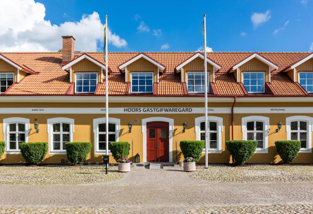 a building with a red door and a red roof at Höörs Gästgifwaregård in Höör