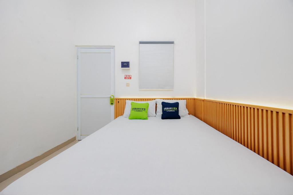 a bed in a room with two pillows on it at Urbanview Hotel near Exit Tol BSD in Ciater-hilir
