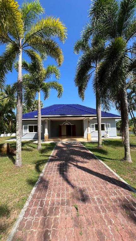 a house with palm trees and a brick driveway at Liina House in Ko Yao Noi