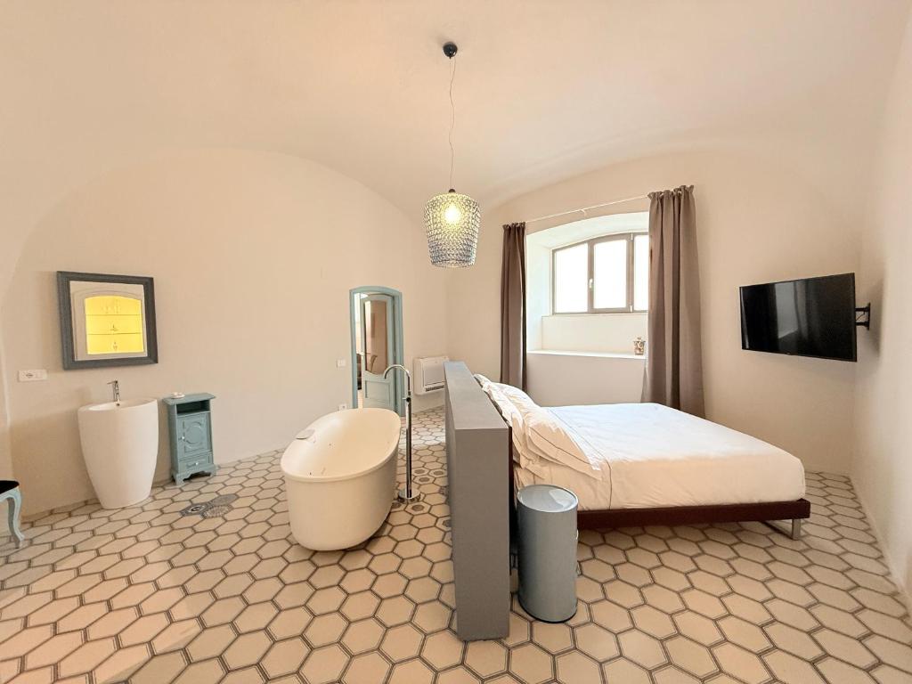 a bedroom with a bed and a tub and a sink at Viaggio Homes Appartamenti da 60 m2 con Jacuzzi Hammam Cucina Patio con Aperitivo di Benvenuto in Faiano