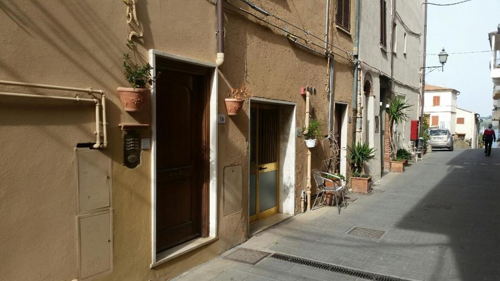 a building with an open door on the side of a street at Lovely Central Apartment in Talamone