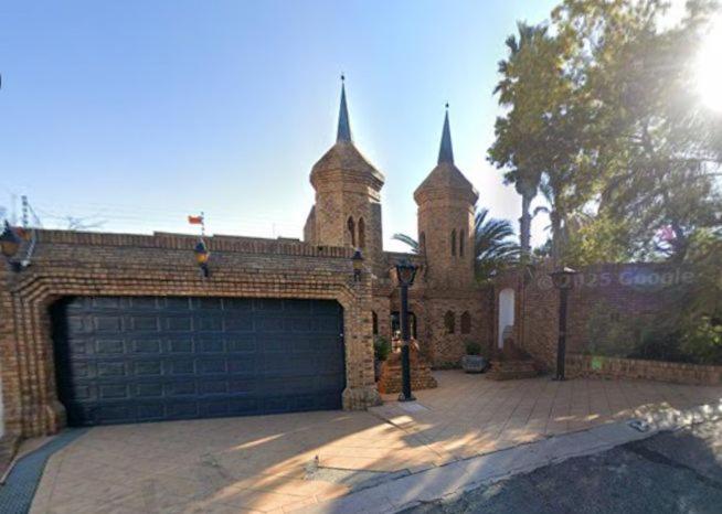 a brick building with a garage door in front of it at Roxana Guestrooms in Johannesburg