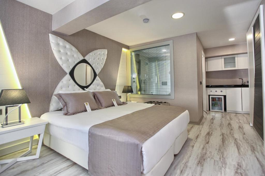 ein Schlafzimmer mit einem großen Bett und einem Spiegel an der Wand in der Unterkunft Demonti Hotel in Ankara