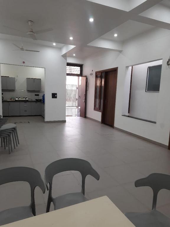 a room with chairs and a table and a kitchen at Saran Homestay in Agra