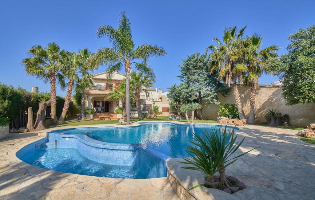 a swimming pool in a yard with palm trees at Can Gual in Inca