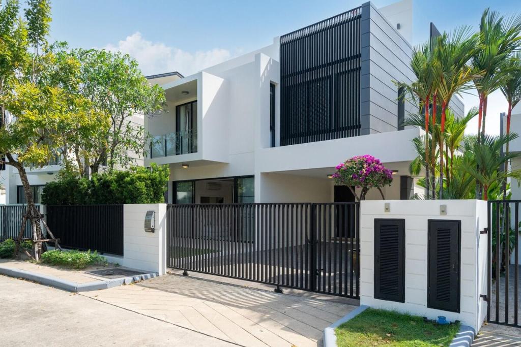 a white house with a black fence at Luxury 5 bed Laguna Park no Pool in Bang Tao Beach