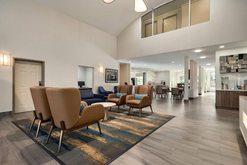 a lobby with a waiting area with chairs and tables at La Quinta Inn by Wyndham Vancouver Airport in Richmond