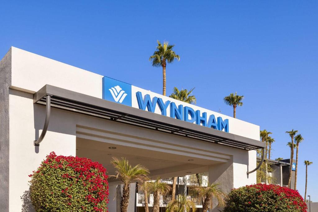 a wynnham sign on a building with palm trees at Wyndham Phoenix Airport - Tempe in Tempe