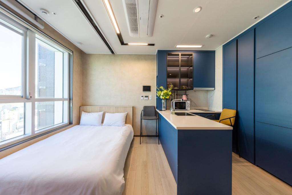 a hotel room with a bed and a kitchen at Nampo Stay 99 in Busan