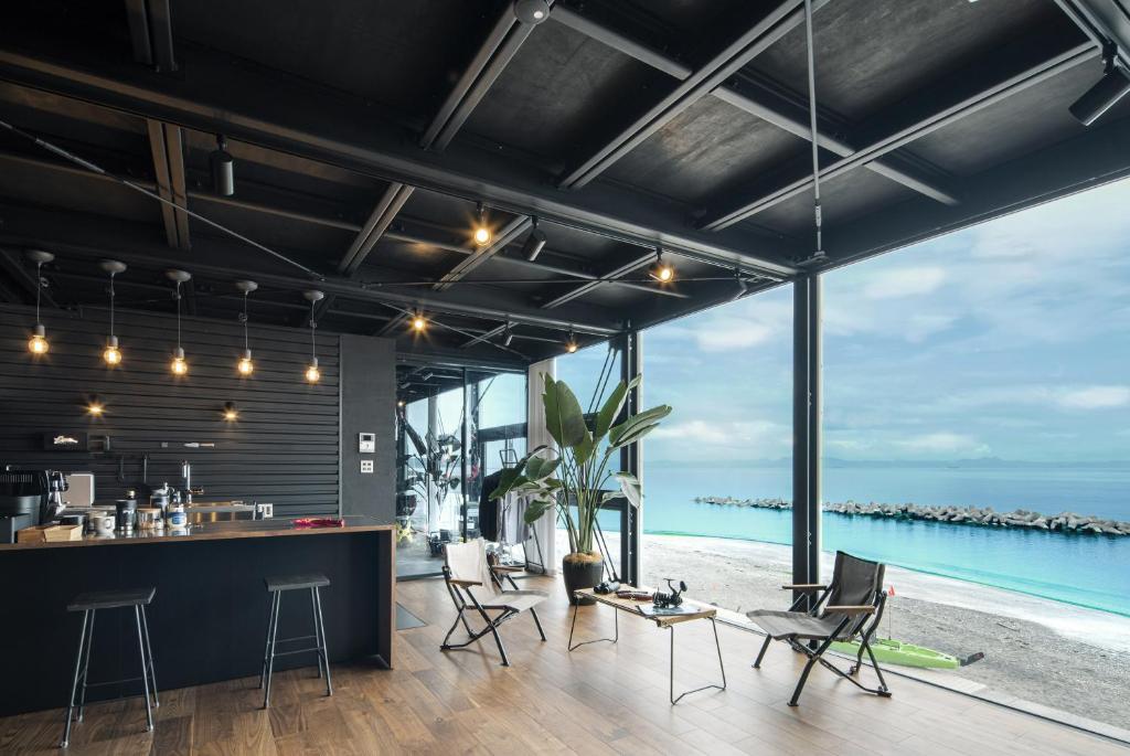 an open kitchen and living room with a view of the ocean at Yokosuka Sky Grey -横須賀のビーチフロントベース- in Yokosuka